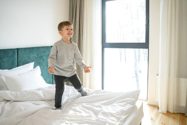 istock Child standing on bed, playing and laughing 1304234530