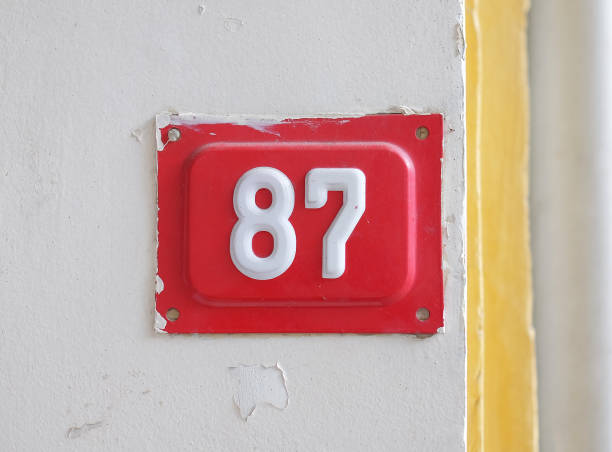 istock Red house number 87 on the wall 1304235626