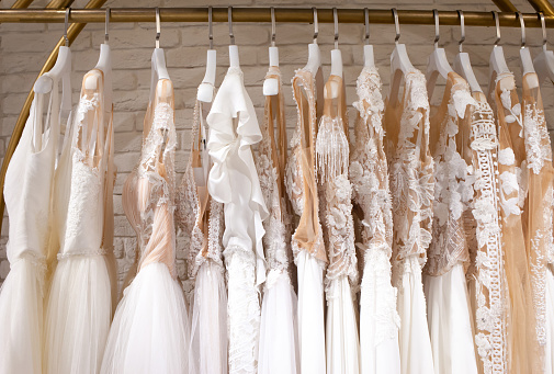 Muchos hermosos vestidos de novia cuelgan en la tienda photo