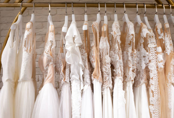 beaucoup de belles robes de mariée pendent dans le magasin - robe de mariée photos et images de collection