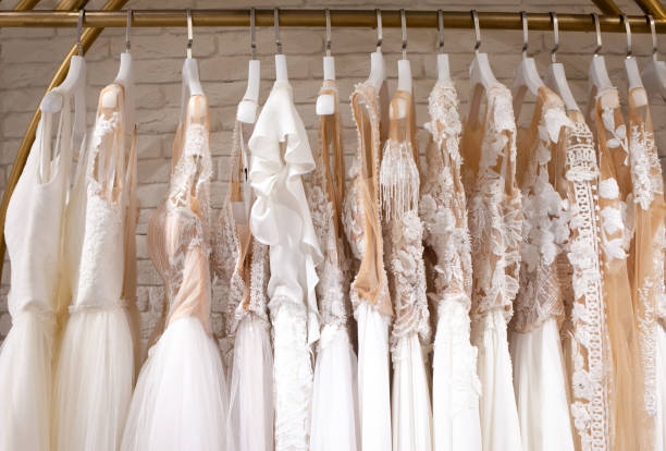 wiele pięknych sukien ślubnych wiszą w sklepie - suknia ślubna zdjęcia i obrazy z banku zdjęć