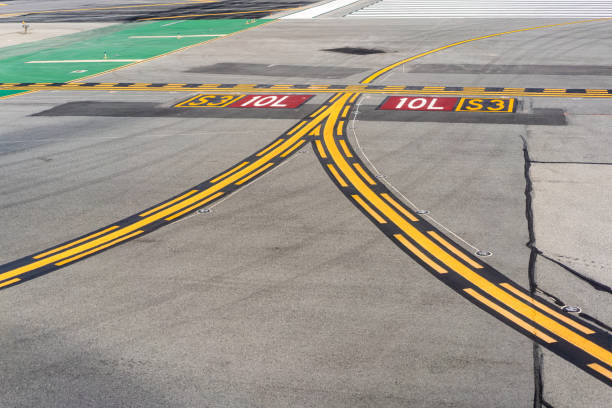 Curving yellow lines on the airport asphalt, with guidelines for taxiing aircraft.