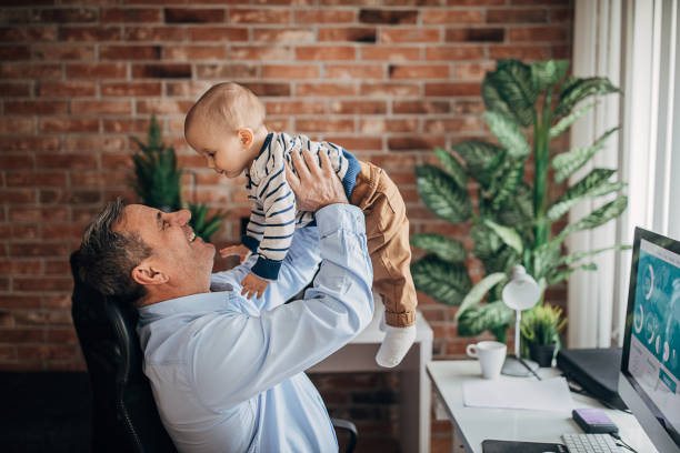 istock Senior man holding his grandson in office 1304238474