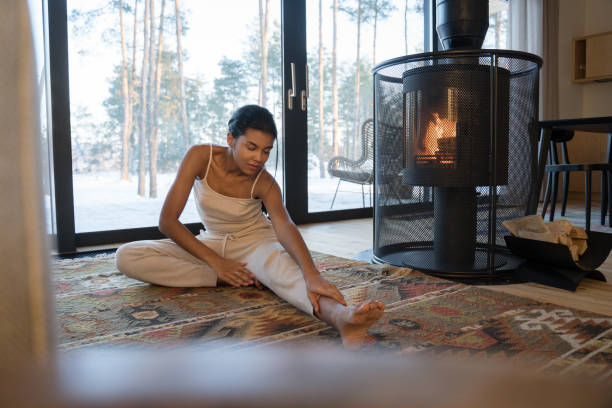 istock Woman stretching to touch toes while sitting on the carpet 1304240962