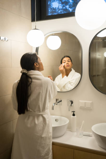 istock Woman in white bathrobe staying in bathroom 1304242232