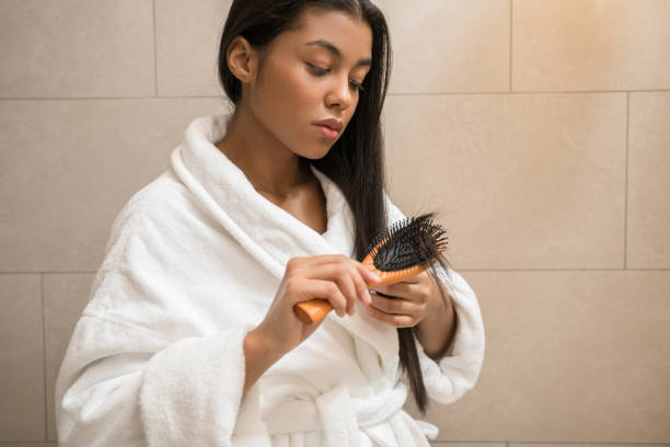 istock Girl looking at her hair tips while standing at the bathroom 1304242235