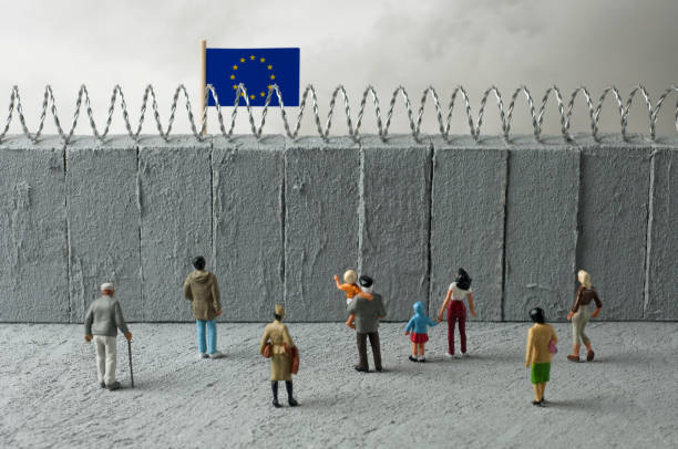 Border 4 European Union refugee crisis concept. People in front of a border wall with a EU flag barbed wire photos stock pictures, royalty-free photos & images