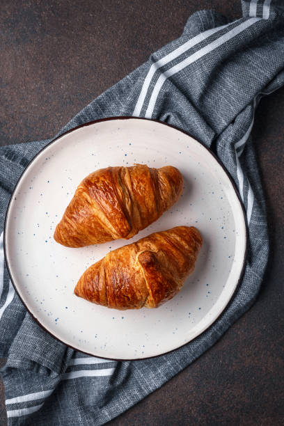 istock Croissants on plate on dark background. Top view 1304247458