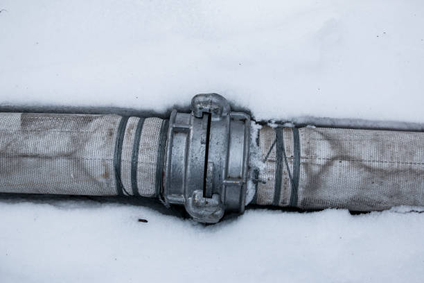 istock Winter. Everything is covered with snow. Leak in the connection of pipes pumping water out of the pond. 1304247607