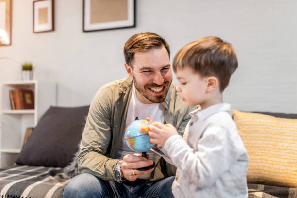 istock Happy father and son looking at globe together. 1304253698