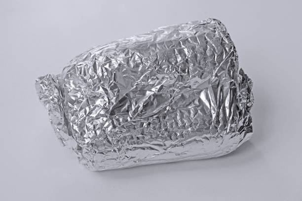 Sandwich wrapped up in silver aluminum foil isolated on white background