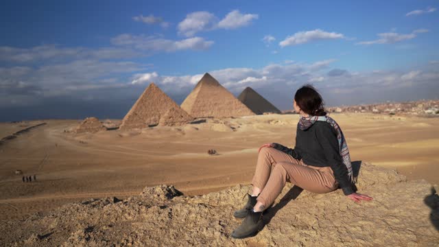 Woman sitting in the desert near the Giza pyramids
