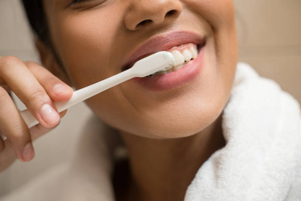 istock Young smiling girl cleaning her teeth 1304256015