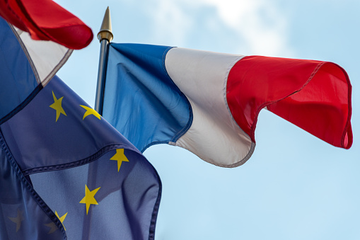 French and European Union flags fluttering together in the wind. Close-up shot