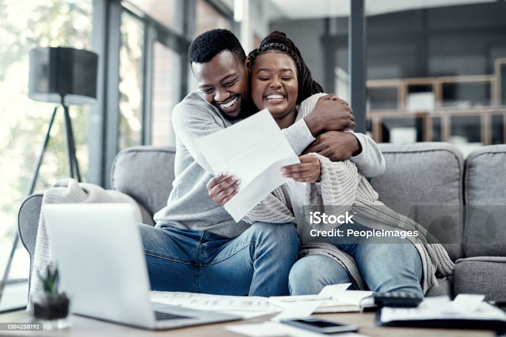 Get out of debt and get back the life you deserve Shot of an affectionate young couple going through paperwork at home Financial Freedom Stock Photo
