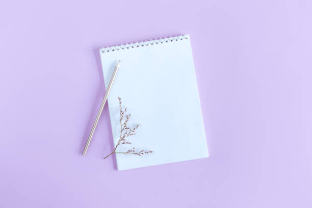 istock Notebook with blank page and pencil on a violet pastel background. Flat lay. 1304258880