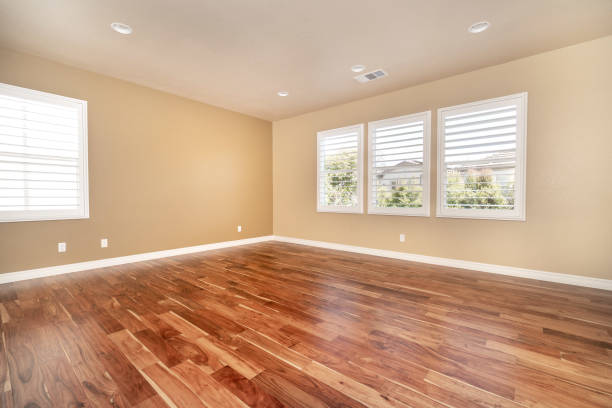 istock Bright beige large empty room with wood floor, molding and windows 1304258887