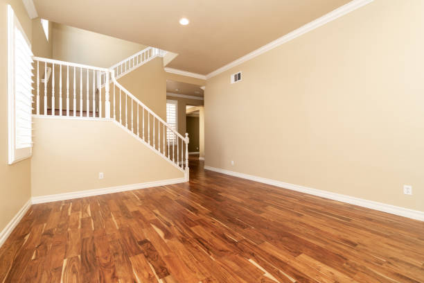 istock Large empty room with wood floor, molding and windows and stairs 1304258946