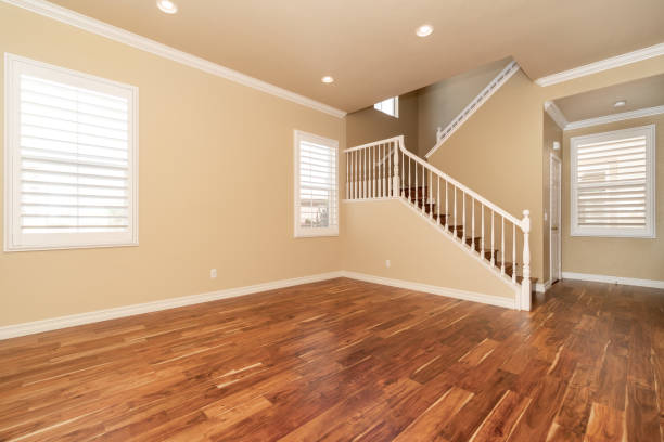 istock Large empty room with wood floor, molding and windows and stairs 1304259010