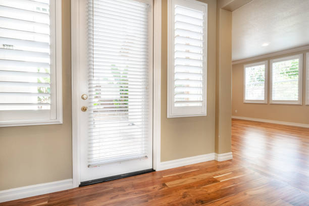 istock Bright beige large empty room with wood floor, molding and windows 1304259164