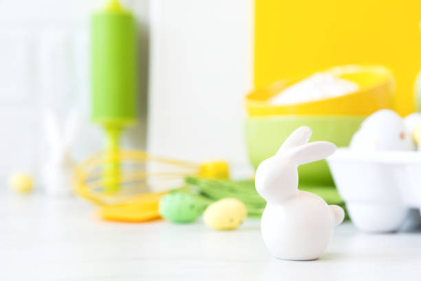 Easter Background for baking with ingredients for cooking. Traditional Easter decoration eggs and rabbit.Kitchen utensils,tools and dishware on on the background white  brick wall.Blank space for a text, front view