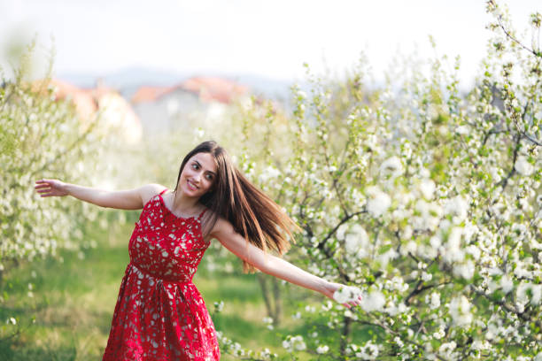 istock Young woman among blooming trees 1304260253
