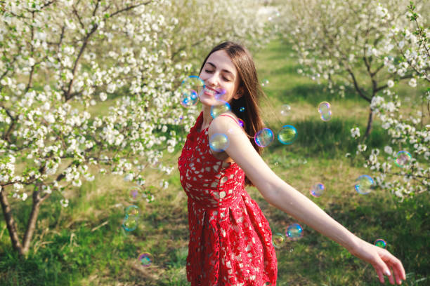 istock Young woman among blooming trees 1304260297