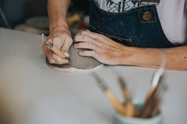 young artisan woman working with her hand a piece of ceramic focus on hand stock photo