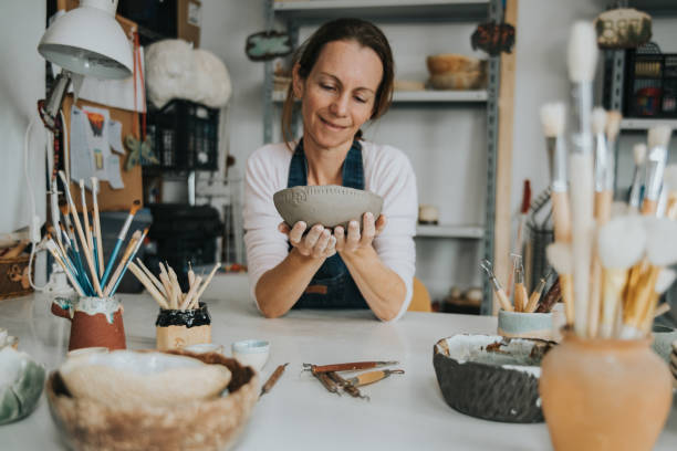 young artisan woman working with her hand a piece of ceramic stock photo