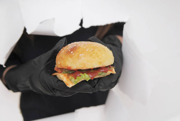 istock hands in black gloves holds hamburger. 1304262731