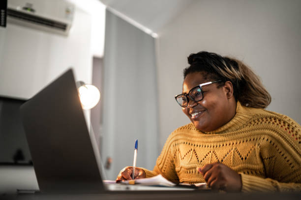 dojrzała kobieta pracująca lub studiująca w domu - working at home mature adult small business laptop zdjęcia i obrazy z banku zdjęć