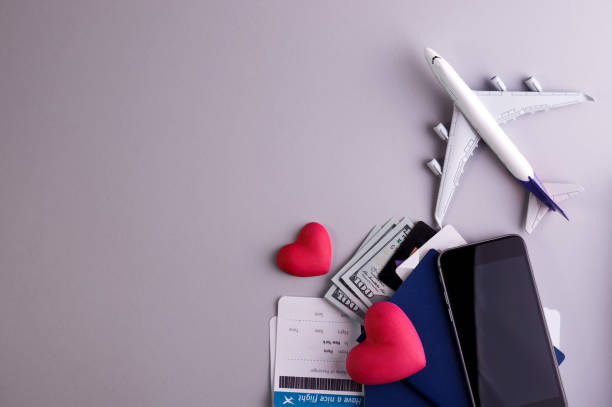 istock Romantic Airplane Travel preparation Concept objects, documents, dollars, passports, boarding pass tickets, glasses, smartphone, and space for text. 1304264584
