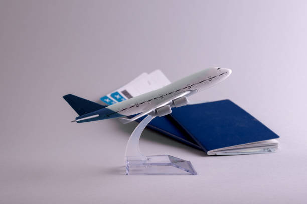 istock Booking flight concept backdrop with airplane model, passports, money, and boarding pass documents on the grey background 1304264637