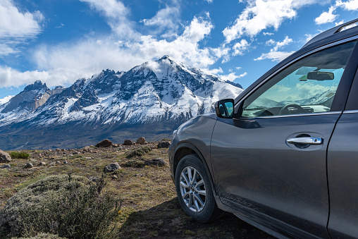 A Nissan car parked on the side of the road in the Torres del Paine National Park, Patagonia, Chile.