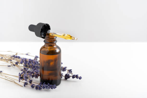 istock Essential oil with a dropper and lavender branches on a white background with copy space. Brown glass cosmetic bottle, serum 1304265905
