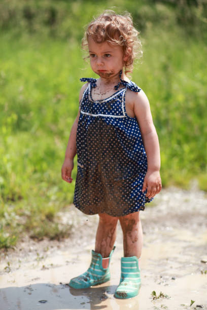 istock Little girl with mud on her hands 1304265932
