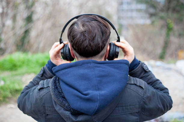 istock Man relaxing on a bench listening to music 1304267102