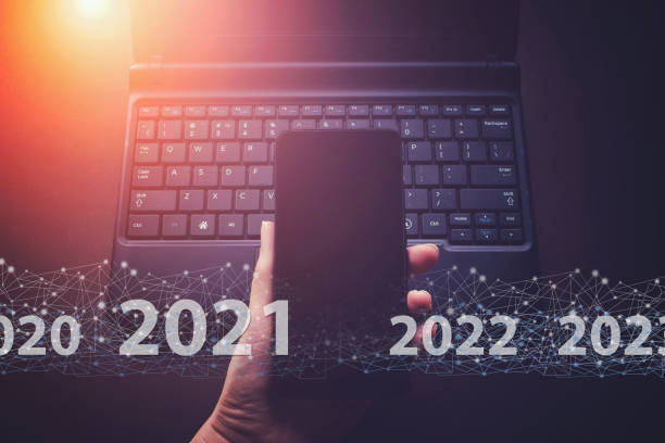 istock Hand hold phone on laptop notebook keyboard background with text 2021. Creative connection background, a new generation network has a wireless speed limit mixed media. 1304267141