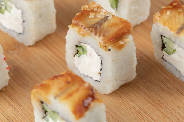 Wooden board of dragon sushi rolls with eel background. High quality photo