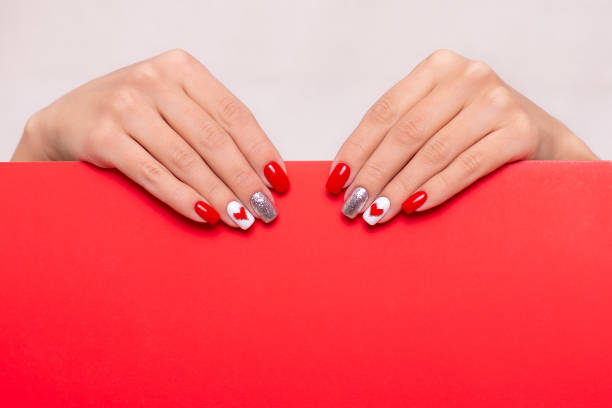 istock Female hands with red manicure nails, hearts design 1304281070