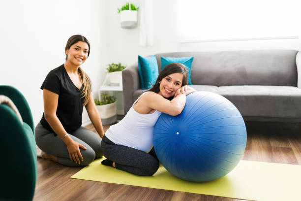 doula hispânica prestes a massagear as costas de uma mulher grávida - human pregnancy massaging midwife prenatal care - fotografias e filmes do acervo