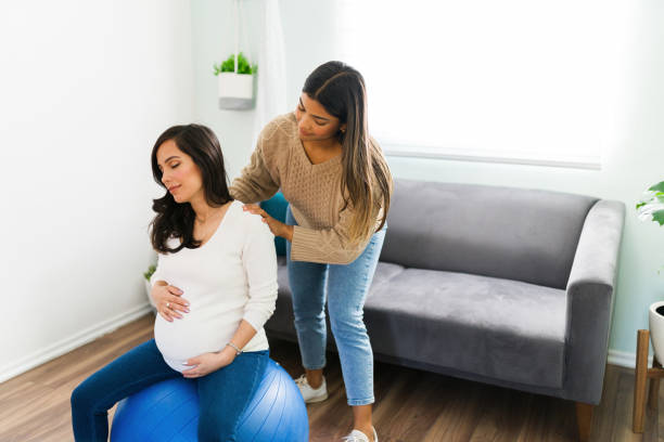 doula latina massageando os ombros de uma mulher grávida - human pregnancy massaging midwife prenatal care - fotografias e filmes do acervo