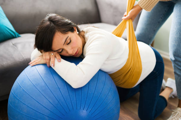 レボゾショールで背中の痛みを和らげる妊娠中の母親 - human pregnancy backache massaging back ストックフォトと画像