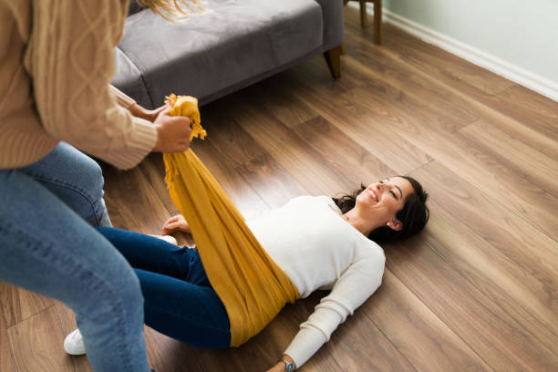 mulher se sentindo feliz enquanto uma doula envolve um rebozo em torno de sua barriga - human pregnancy massaging midwife prenatal care - fotografias e filmes do acervo