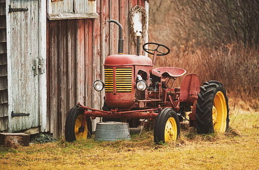 A 1940's era tractor beside a neglected barn.