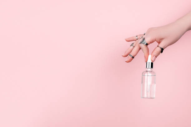 istock Female hand holding hyaluronic bottle from torn paper 1304298992