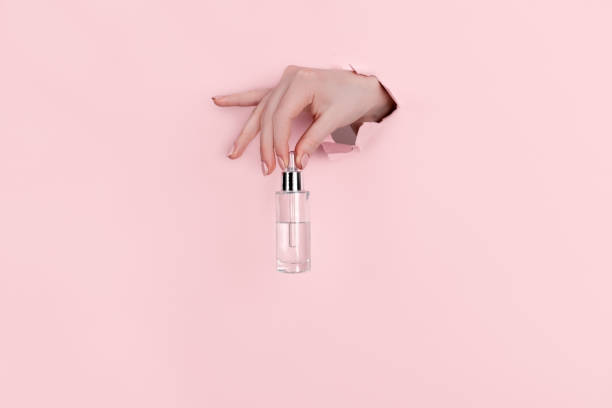 istock Female hand holding hyaluronic bottle from torn paper 1304299016