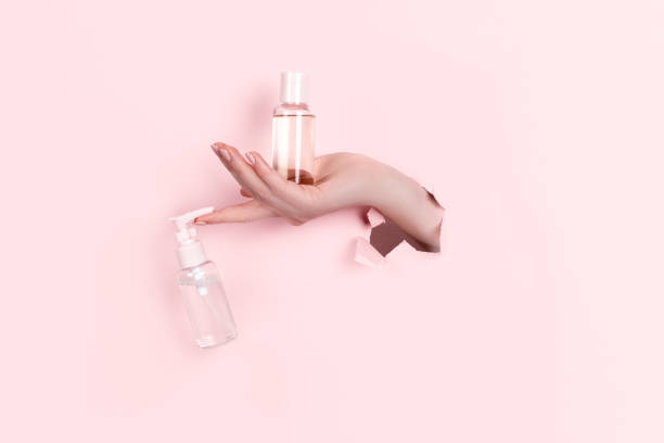 istock Female hand holding hyaluronic bottle from torn paper 1304299021