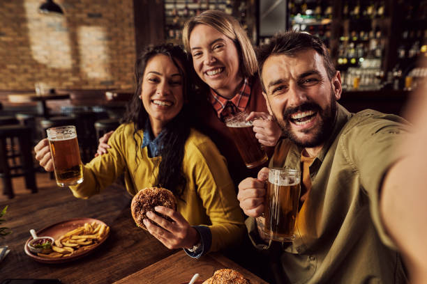 istock Group of happy friends having fun while taking selfie in a pub. 1304304567