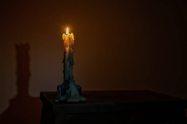 istock Burning candle stands on a wooden table in the dark 1304306047